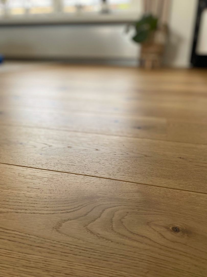 Nahaufnahme eines geölten Holzbodens mit natürlicher Maserung in einem Wohnraum.