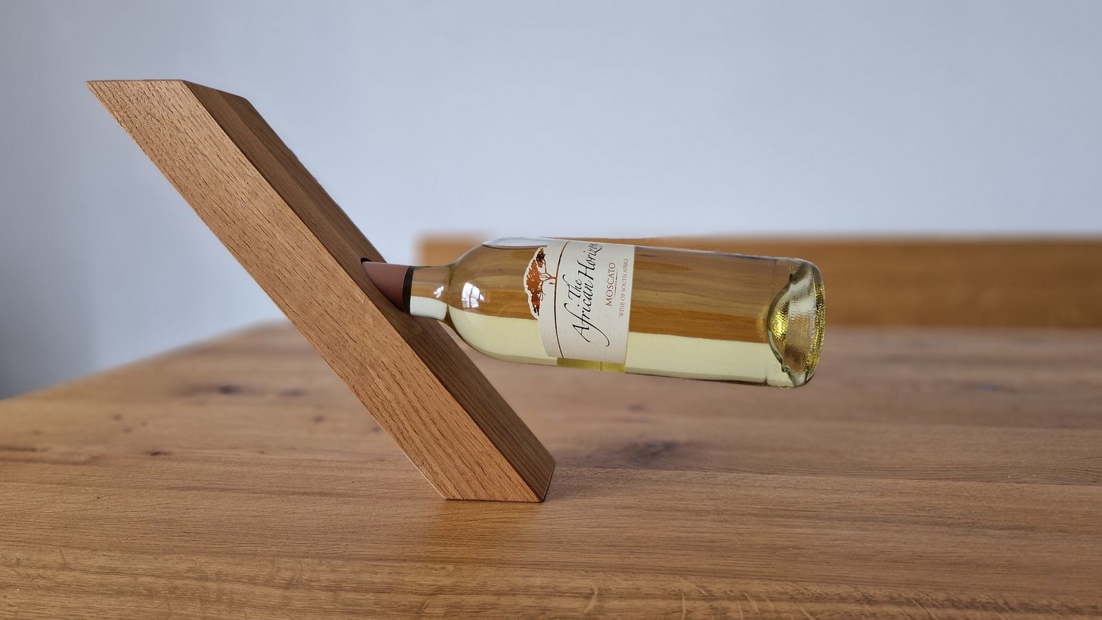 Schwebender Weinhalter aus Holz - Holzhalter mit einer eingesteckten Weinflasche, der durch Balance die Flasche scheinbar schweben lässt.